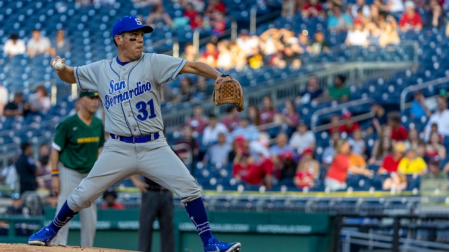 A photo of Rep. Pete Aguilar pitching at the game