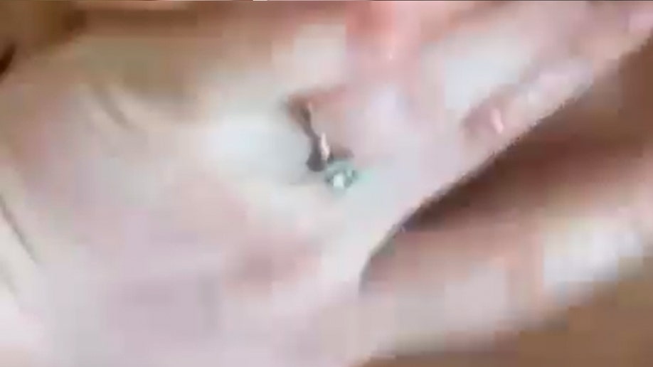 Blurry screengrab of Jane Doe’s ring