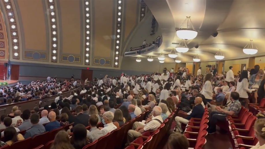 A photo of dozens of medical students exiting their White Coat Ceremony