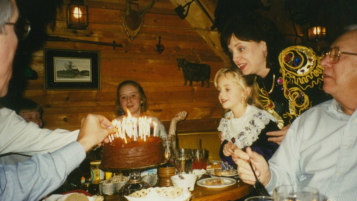JonBenet Ramsey blows out candles on a birthday cake