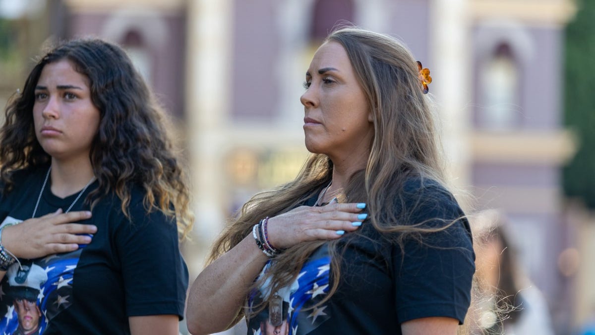 Attendants have hands on their hearts during ceremony