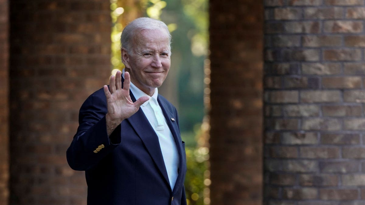 President Joe Biden waves to photographers