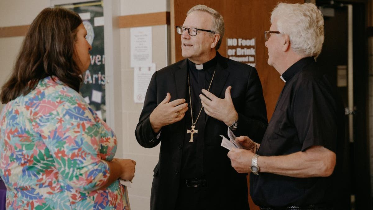 Bishop Barron speaking with two other people