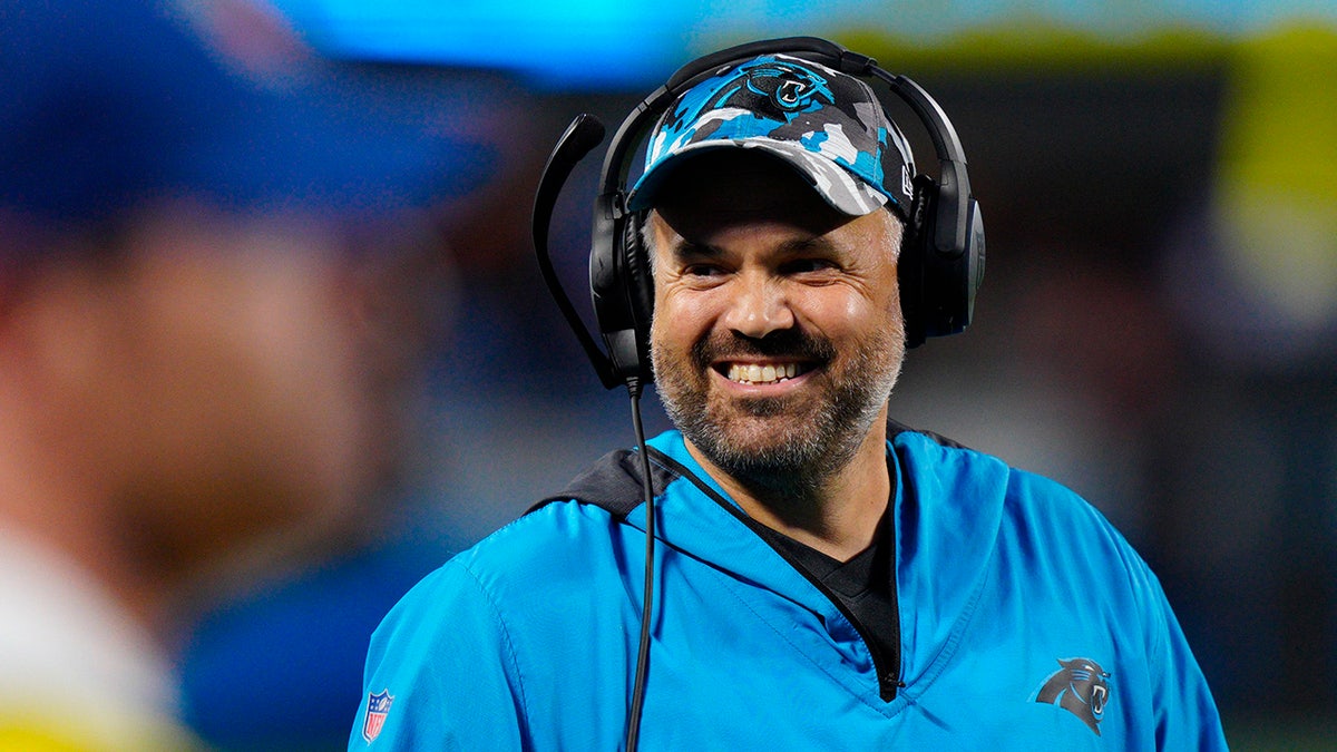 Matt Rhule smiling on the sideline of a Panthers vs. Bills preseason game