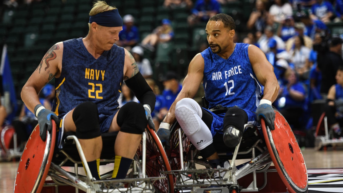 A player for team Navy and a player for team Air Force bang wheels in a game of wheelchair rugby