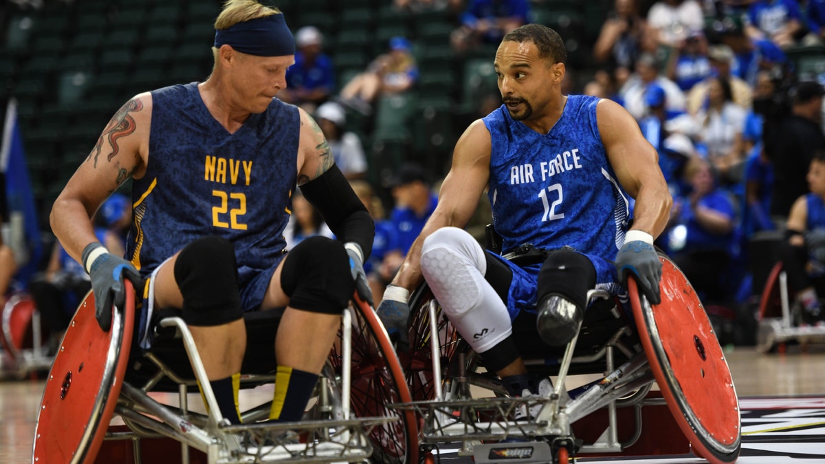 A player for team Navy and a player for team Air Force bang wheels in a game of wheelchair rugby