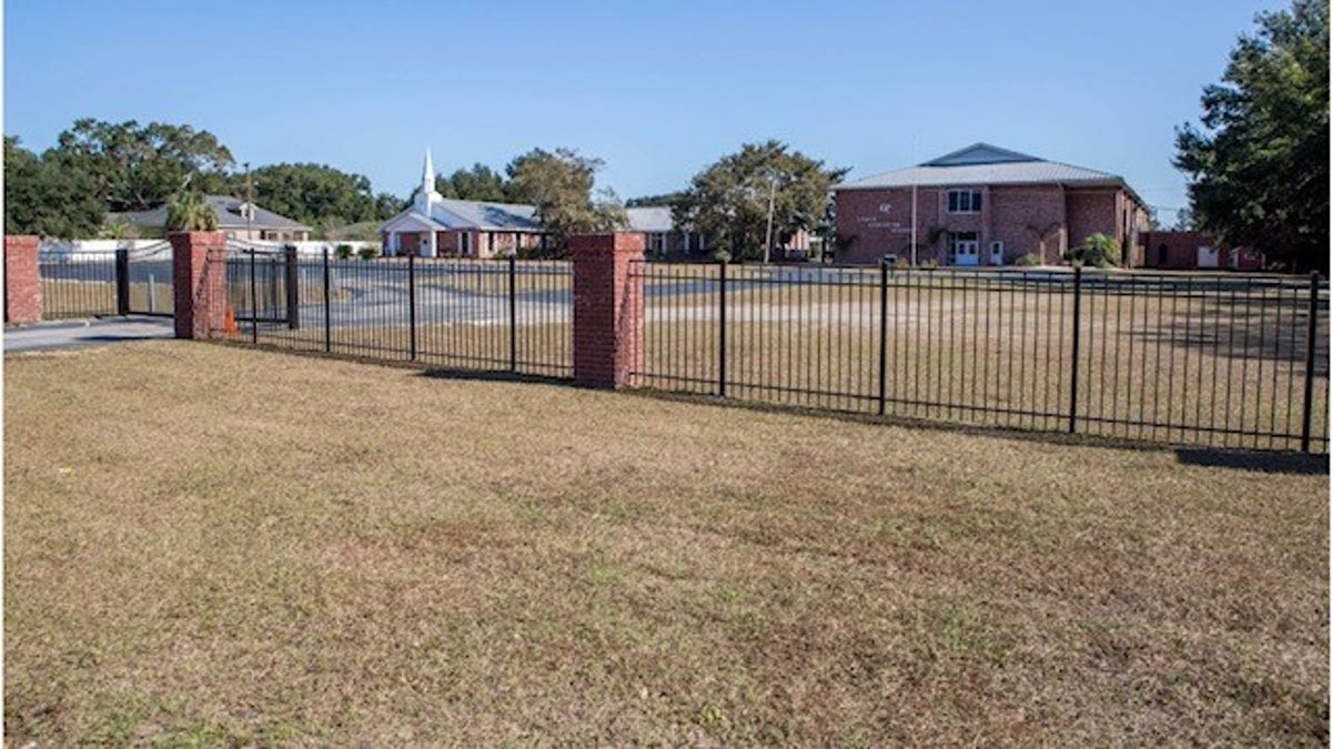 Photo shows outside view of Grace Christian School with fence line and chapel seen in the distance 
