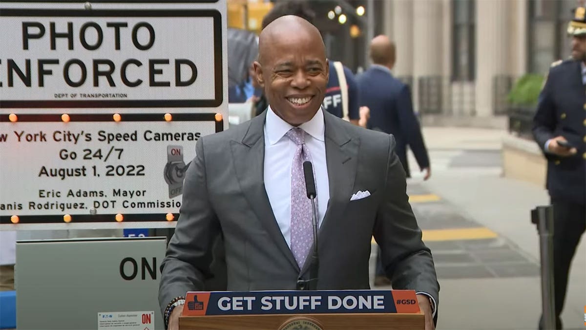 NYC Mayor Adams speaks in a gray suit at press conference