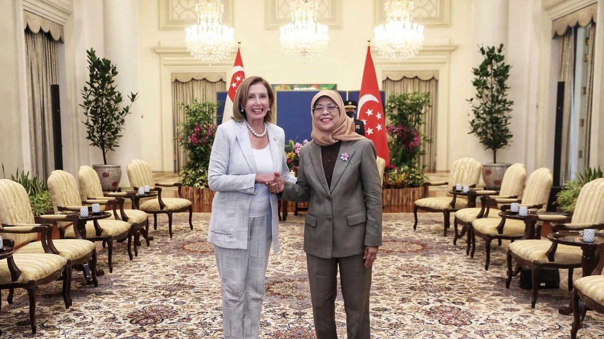 Nancy Pelosi and Singapore President Halimah Yacob smile and shake hands