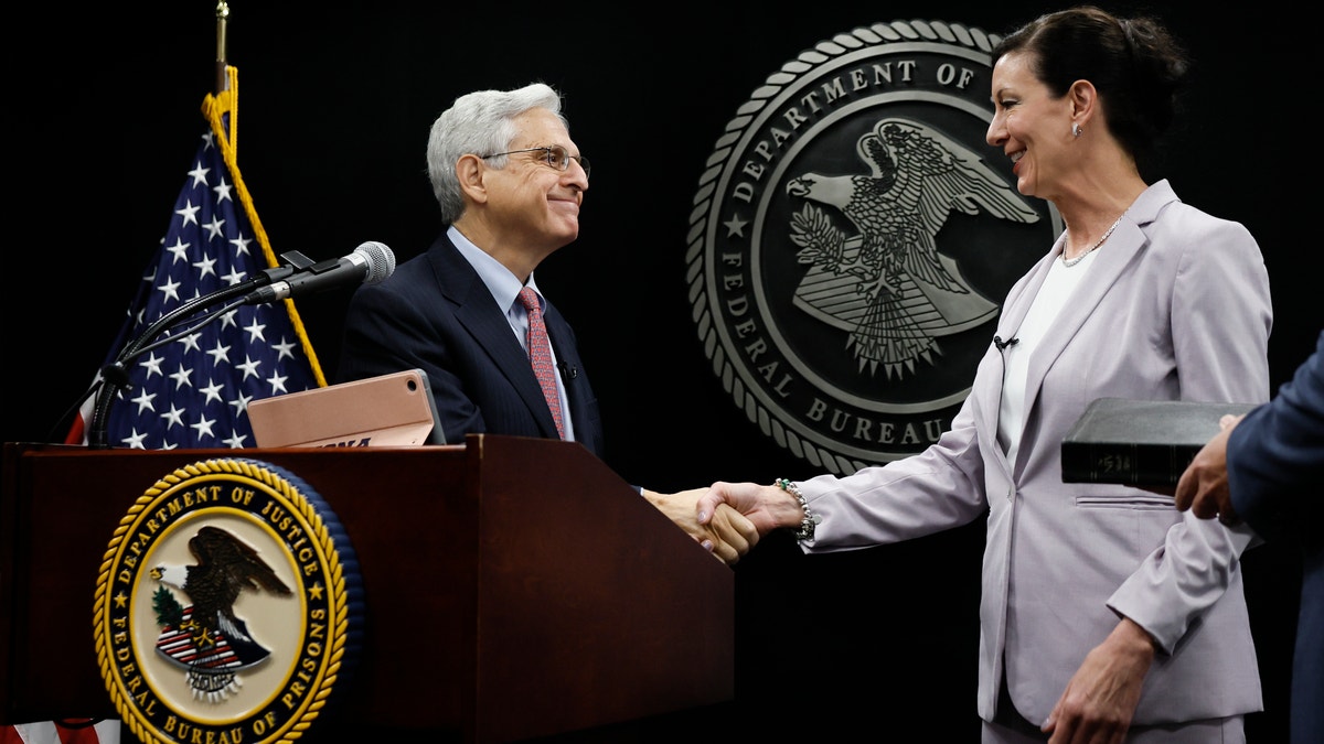 Attorney General Merrick Garland shakes hands with Colette Peters