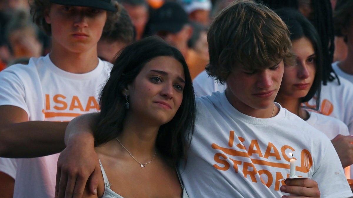 Alyssa Lord, 17, is consoled by a friend during a candlelight vigil