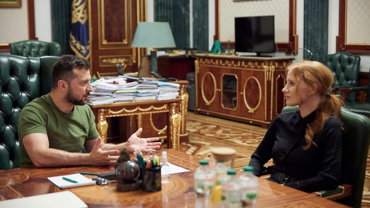 Zelenskyy and Chastain sitting at a table talking