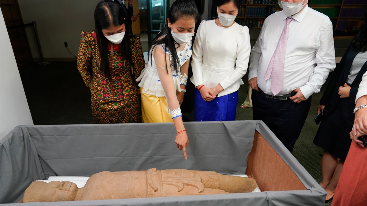 People look at some of the Cambodian antiquities recovered by the United States