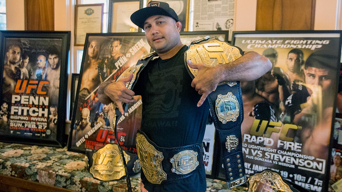 BJ Penn holding UFC championship belts