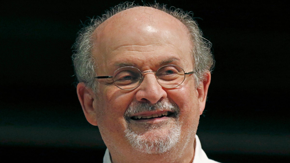 Salman Rushdie wearing white shirt at book signing