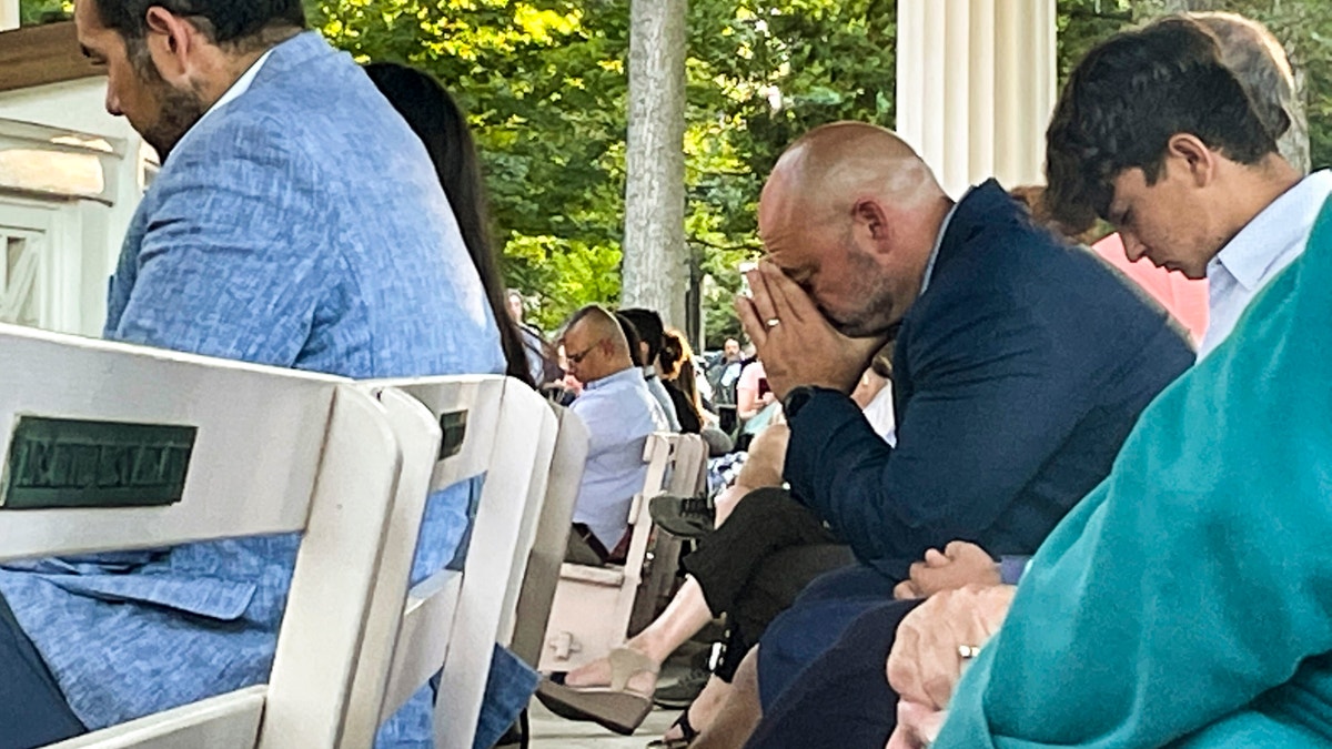 People gather at an evening vigil pray and observe