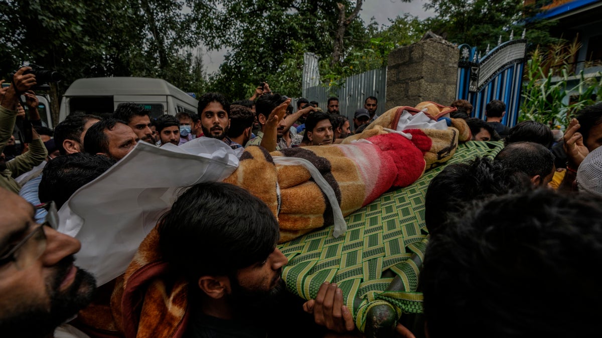 Kashmiri villagers carry the body of Sunil Kumar