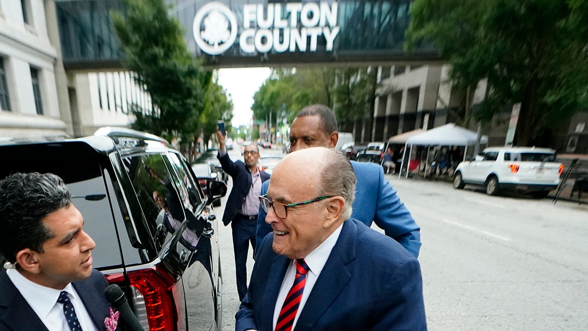 Giuliani surrounded by media in Fulton County