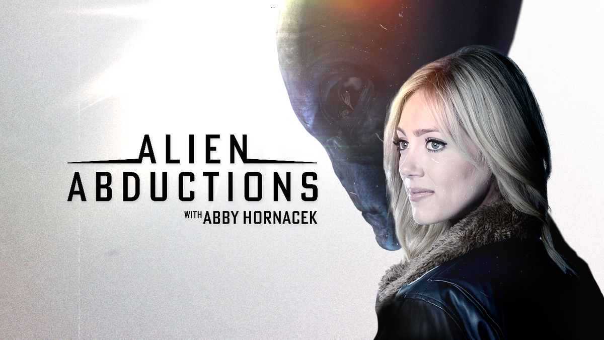 Host Abby Hornacek in front of an alien