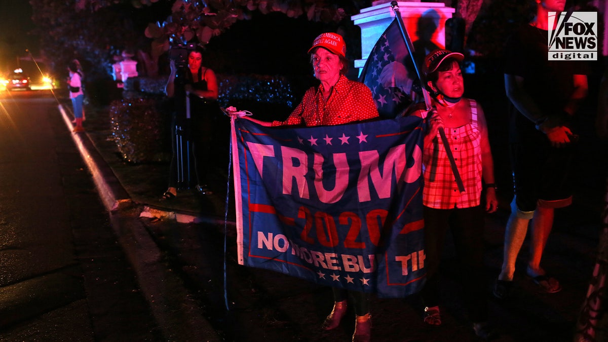 Trump supporters holding flags and signs outside Mar-a-Lago