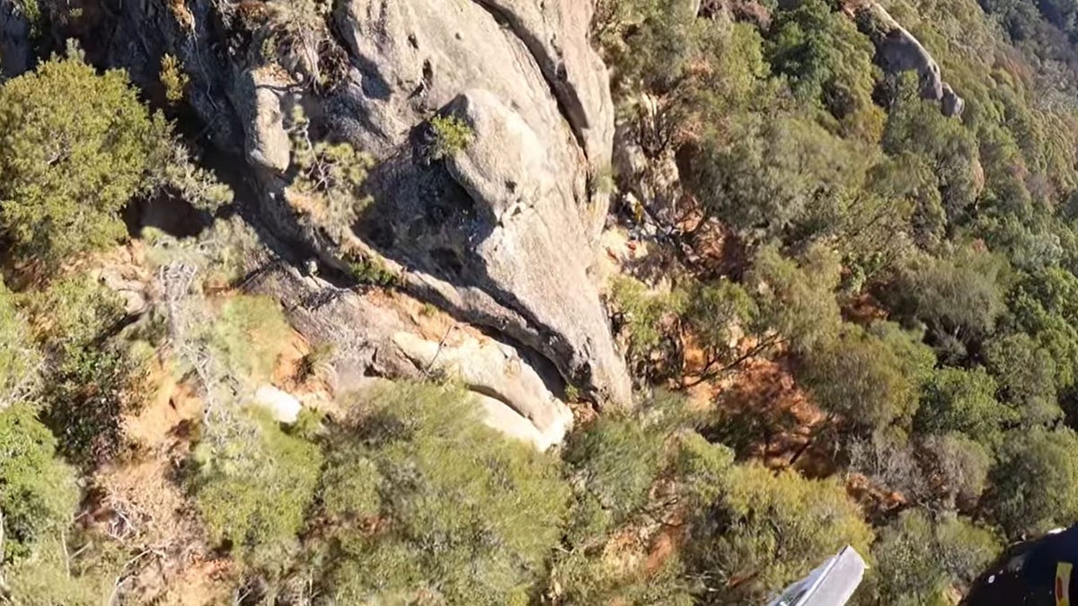fallen climber with rescuers on ledge