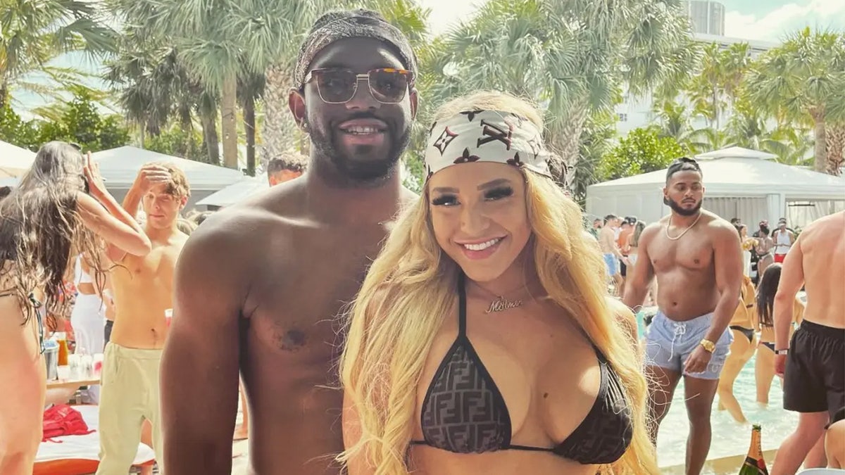 Christian Obumseli and Courtney Clenney pose on a beach