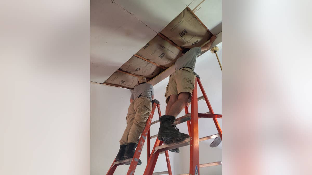 Volunteers making repairs to a damaged home