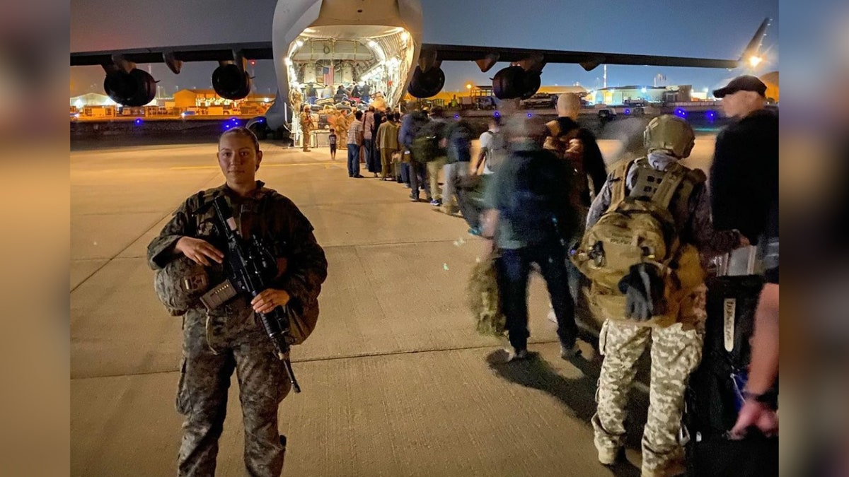 Sgt. Nicole Gee at the Hamid Karzai International Airport escorting evacuees onto a plane on Aug. 22, 2021.