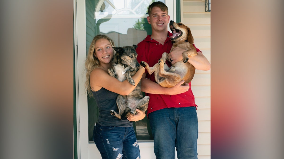 Gee and her husband hold dogs