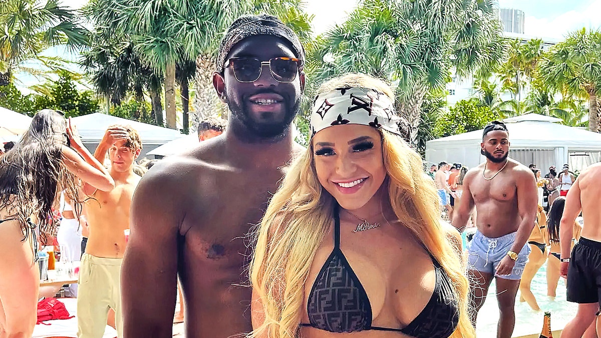 Christian Obumseli and Courtney Clenney pose on a beach