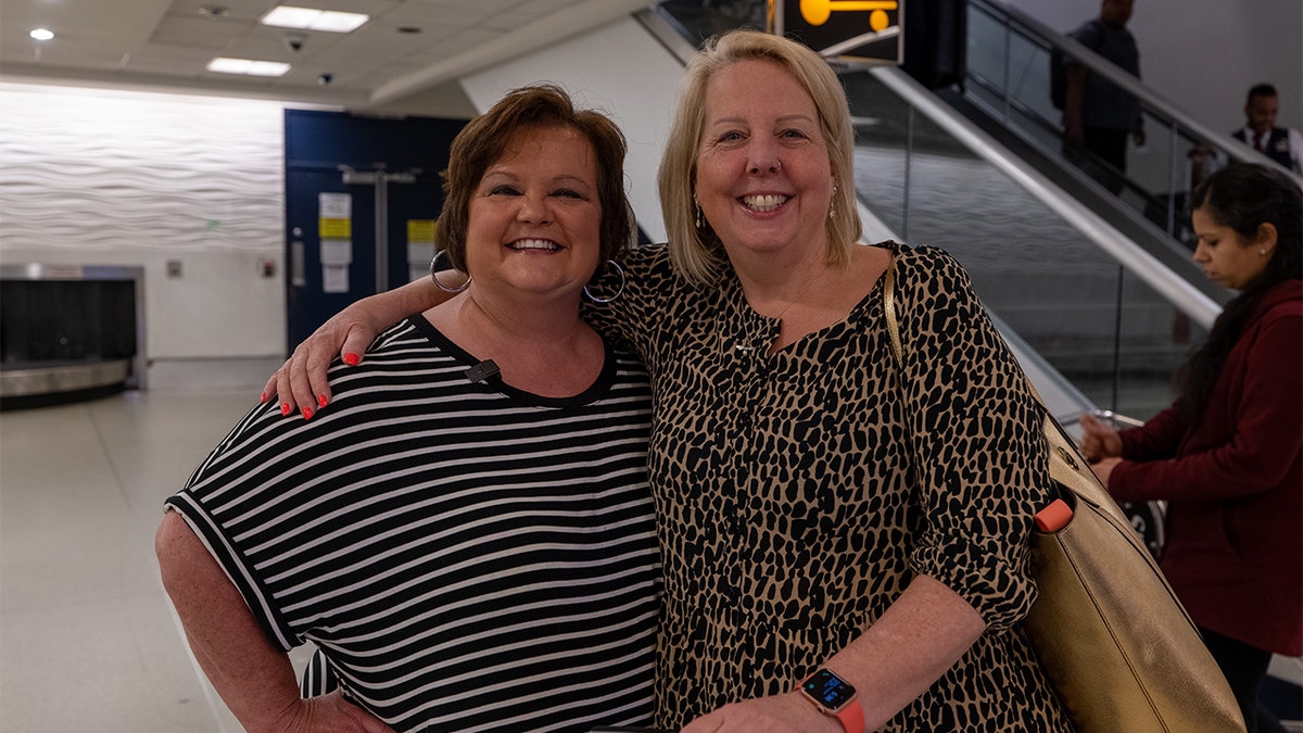 Diane and Mary posing at the airport