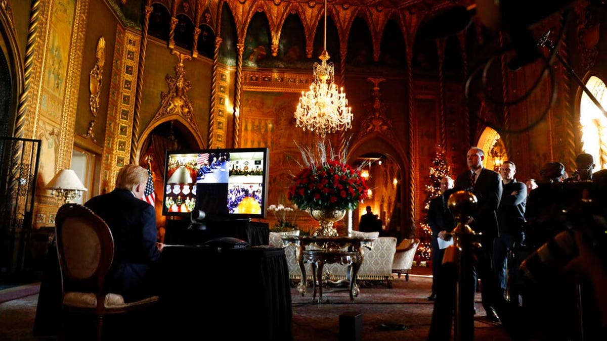 FILE: Then-President Donald Trump listens during a Christmas Eve video teleconference with members of the military at his Mar-a-Lago estate in Palm Beach, Fla., Dec. 24, 2019.