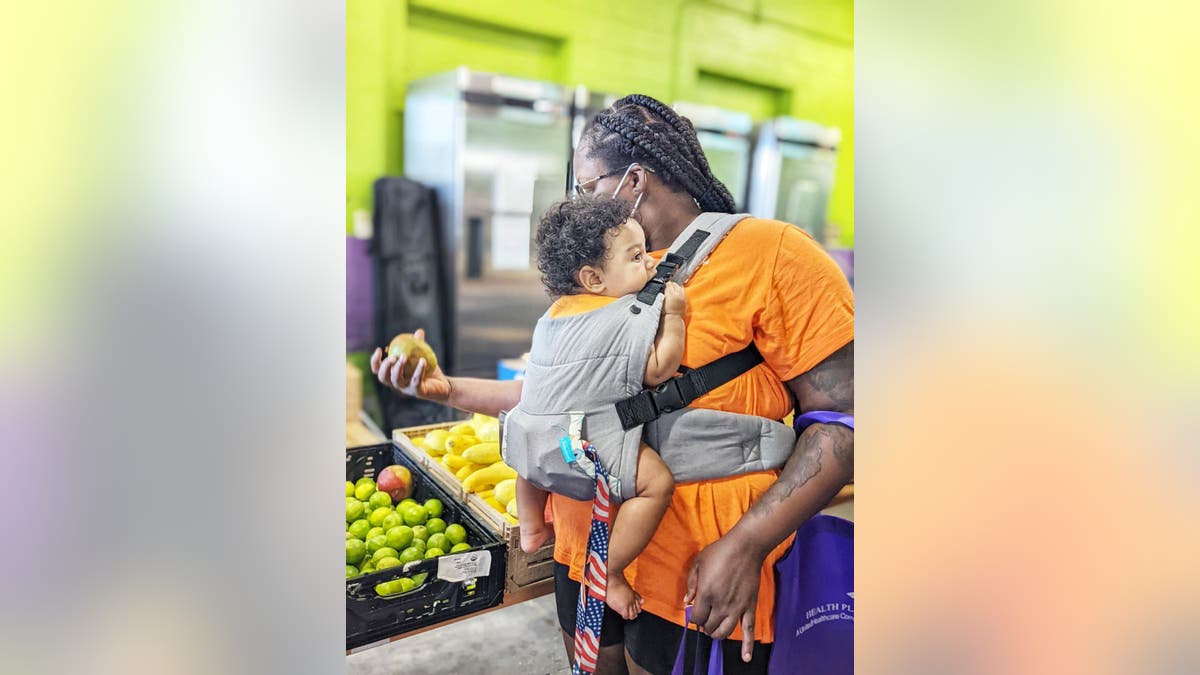 A parent and child pick up produce at a Food Bank of Northern Nevada location