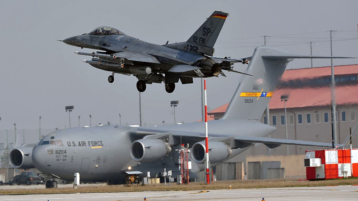 F-16 successful  beforehand   of a C-17 astatine  Aviano Air Base