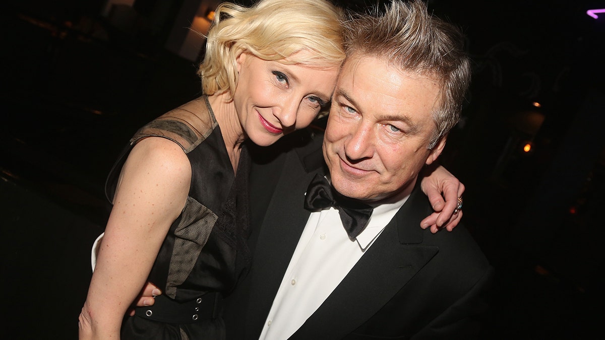 Anne Heche in a black dress and Alec Baldwin in a suit