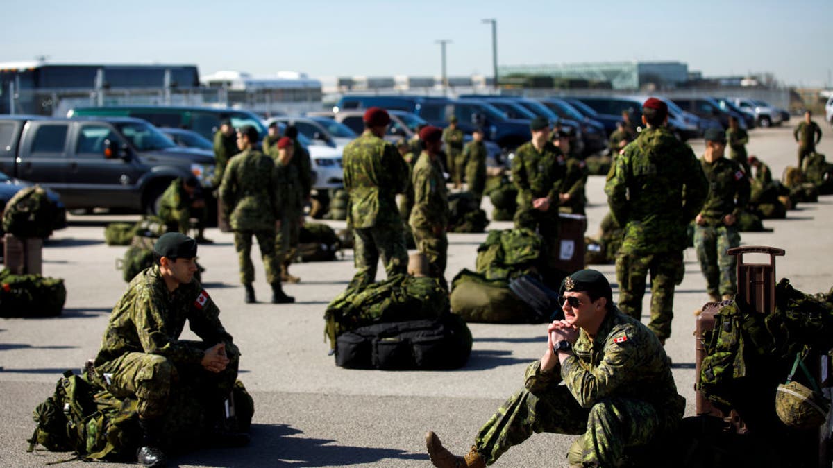 Members of Canadian military sit on ground in Toronto