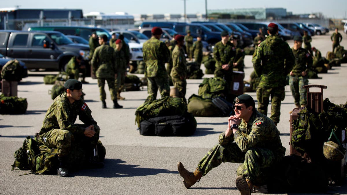 Members of Canadian military sit on ground in Toronto