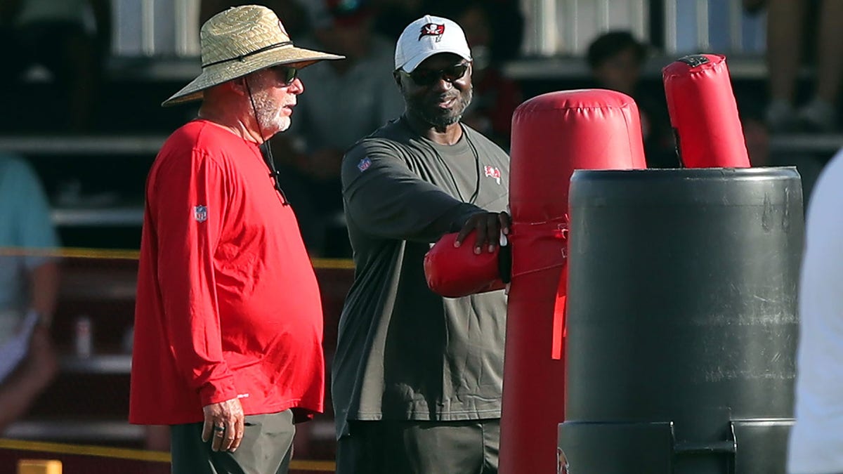 Bruce Arians speaks with Tampa Bay head coach Todd Bowles
