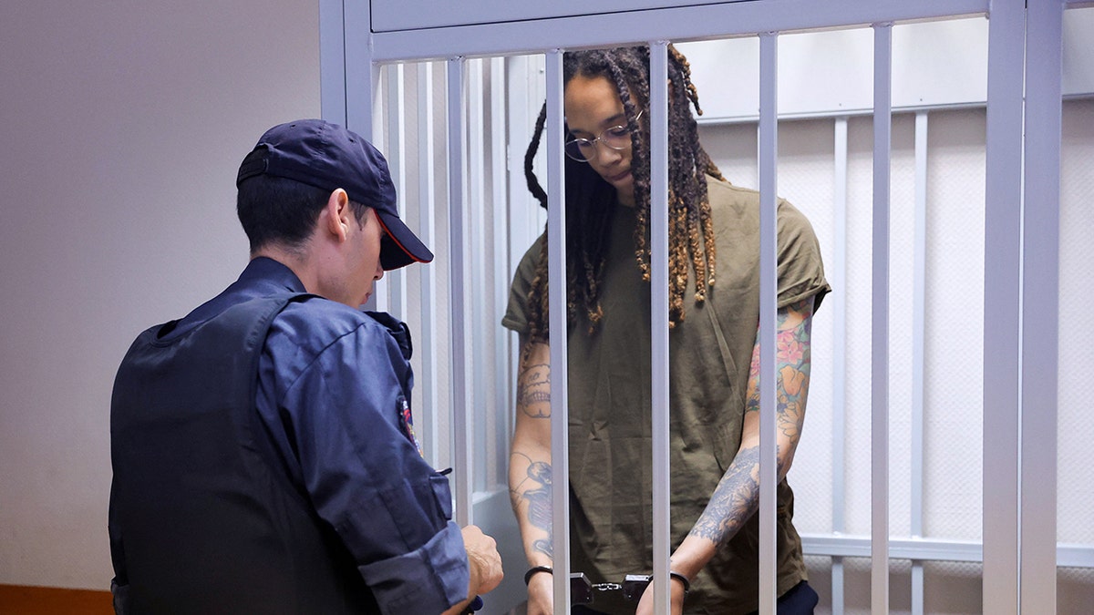 Brittney Griner stands in a defendants' cage