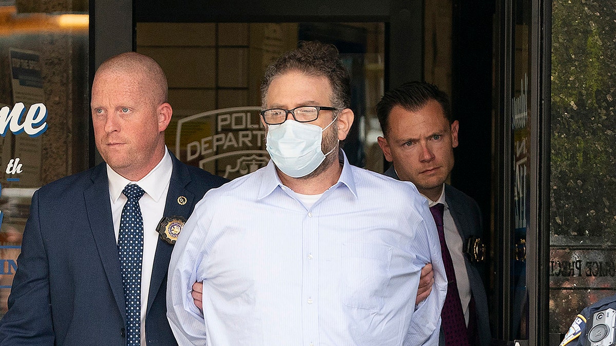 Glenn Hirsch in a mask led out of court