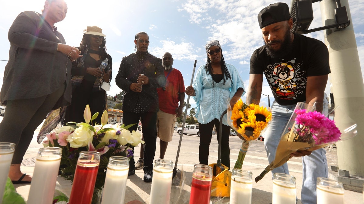 Man leaves flowers at memorial site for Los Angeles car crash victims