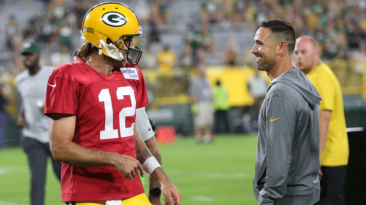 Aaron Rodgers talks with Packers head coach Matt LaFluer 