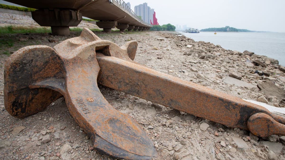 An anchor lies on an exposed tidal flat along China's Yangtze River