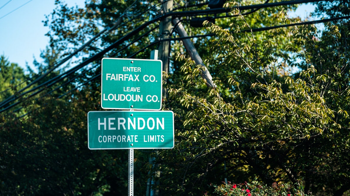 Herndon, Virginia limits road sign in front of trees