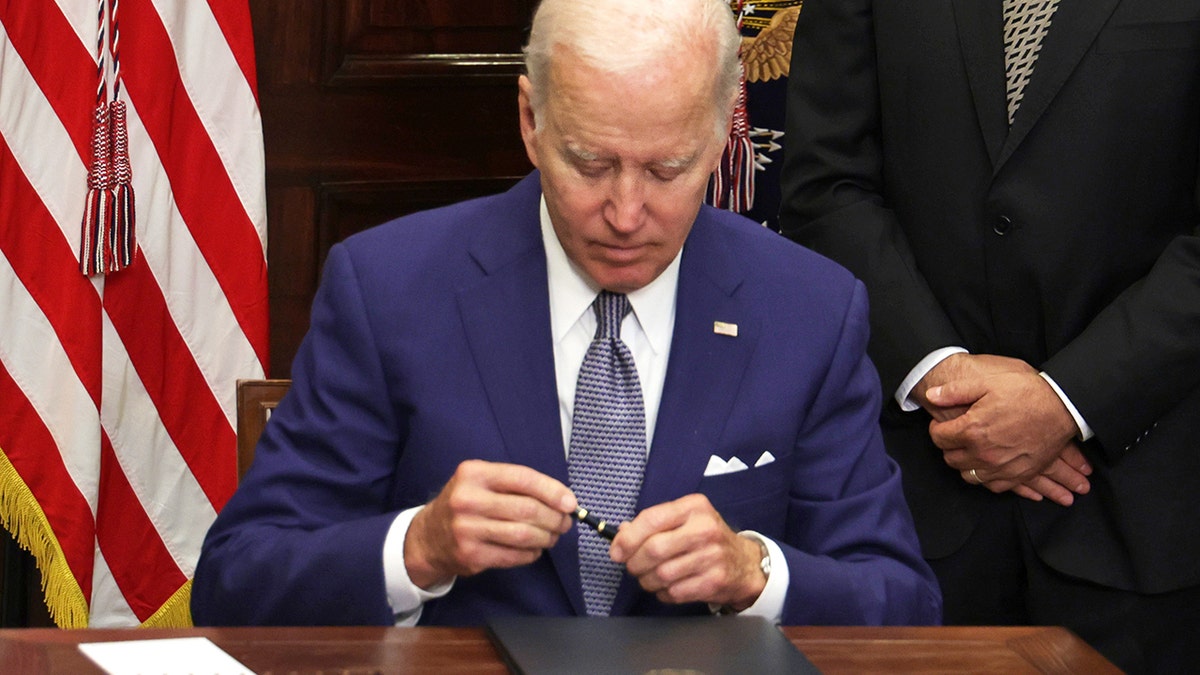 Biden signing an execute order at the White House