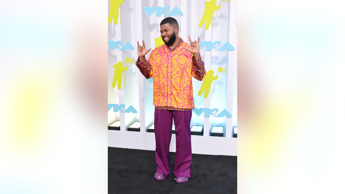 Khalid wears orange and magenta ensemble