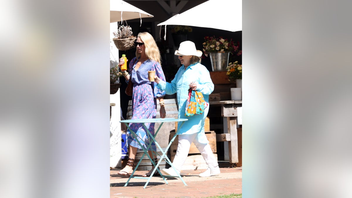 Hillary Clinton in blue and white pictured with a friend in the Hamptons