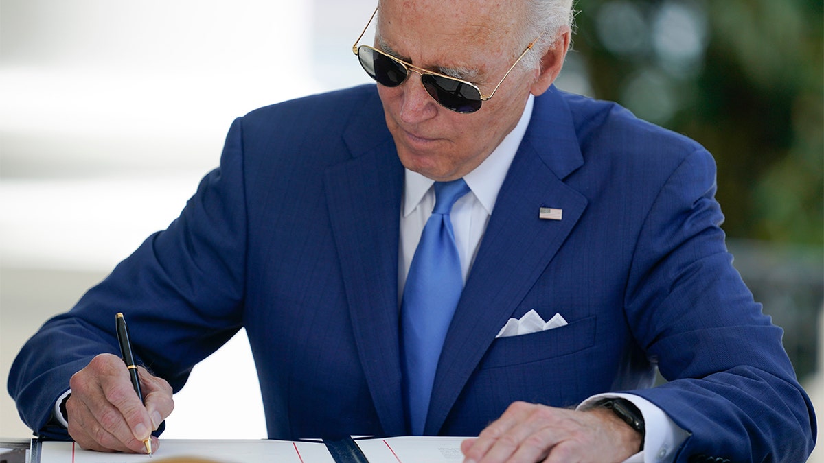 President Biden signs a bill at the White House