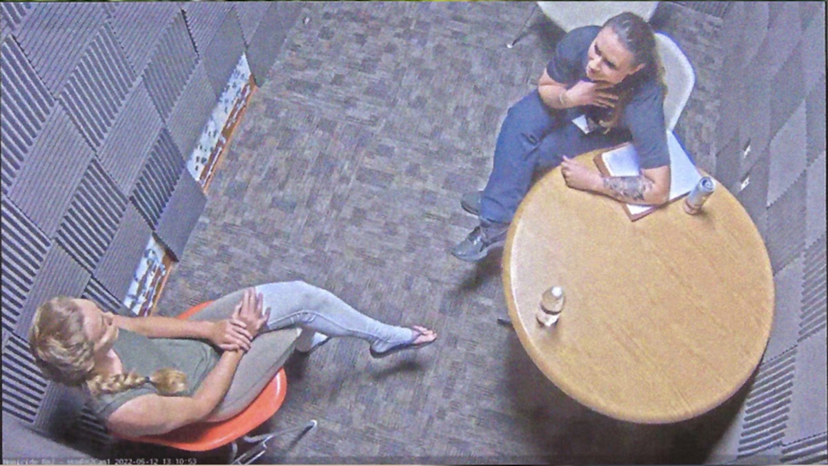 Kaitlin Armstrong with legs and hands crossed seen from above during interrogation