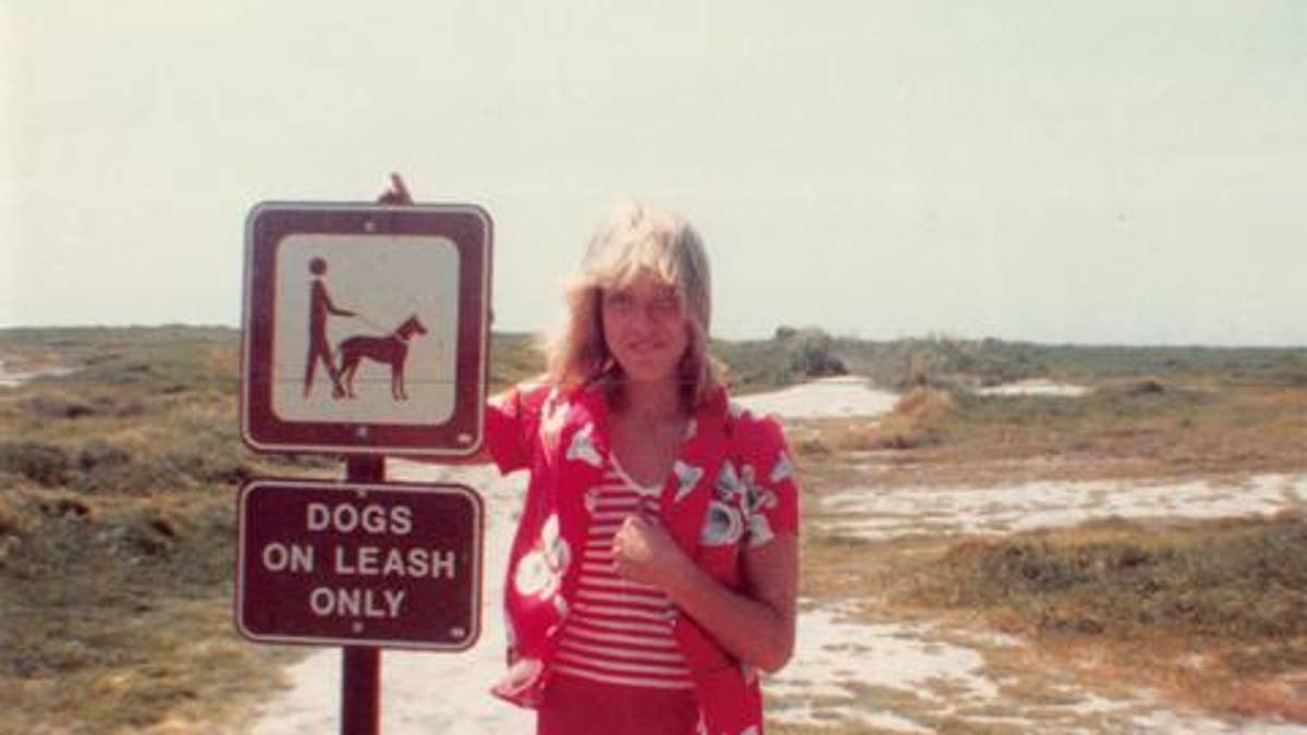 Karen Stitt posing next to sign